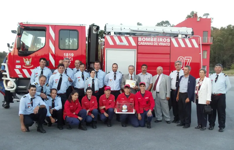 Bombeiros, dirigentes e convidados reunidos em frente a um veículo de combate a incêndios da corporação